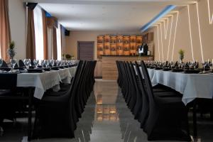 uma fila de mesas e cadeiras com copos de vinho em Sax-Win em Pozega