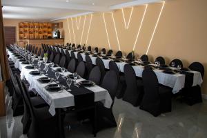 a long table with black chairs and white tablecloths at Sax-Win in Požega