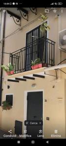 a building with a balcony with potted plants on it at A' casuzza in Palermo