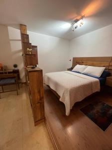 1 dormitorio con 1 cama con cabecero de madera en Lomas de las Mercedes, en Caracas
