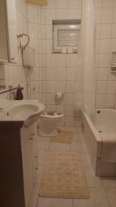La salle de bains est pourvue d'un lavabo, de toilettes et d'une baignoire. dans l'établissement Kupres Desktop - mountain house, à Kupres