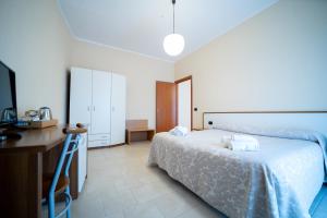 um quarto com uma cama, uma mesa e uma secretária em Hotel Parnaso em Trebisacce