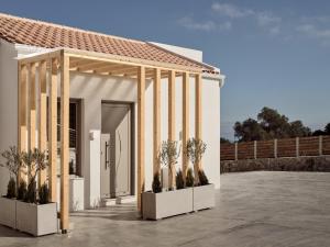 a small white house with plants in front of it at Ocean Luxury Villas in Volimes