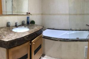 a bathroom with a sink and a bath tub at Grand appartement de luxe sur Anfa in Casablanca