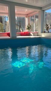 a swimming pool in a house with blue water at Готель Колиба Колорит in Tatariv