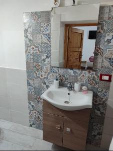 ein Bad mit einem Waschbecken und einem Spiegel in der Unterkunft A' casuzza in Palermo