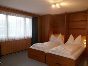 una camera da letto con un grande letto con cuscini bianchi di Apartment Chalet Chiebrendli by Interhome a Grindelwald