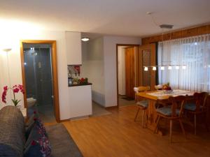 soggiorno e sala da pranzo con tavolo e sedie di Apartment Chalet Chiebrendli by Interhome a Grindelwald