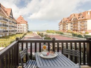Una mesa con un plato de comida en un balcón. en Apartment Les Normandières-11 by Interhome, en Cabourg