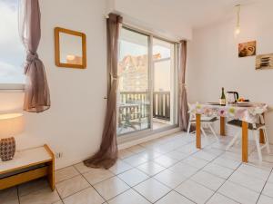 Una sala de estar con una mesa y una gran ventana. en Apartment Les Normandières-11 by Interhome, en Cabourg 17 fotos más