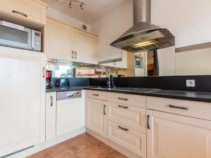 a kitchen with white cabinets and a sink at Apartment Le Grand Large by Interhome in Capbreton