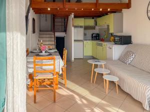 a kitchen and a living room with a table and a couch at Apartment Les Saladelles-4 by Interhome in Le Grau-du-Roi