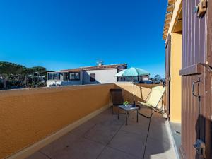 a balcony with two chairs and an umbrella at Apartment Les Caraïbes du Levant by Interhome in Le Barcarès