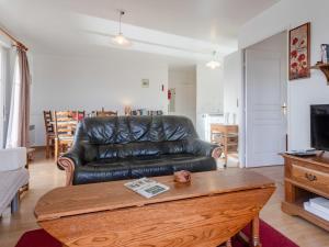 a living room with a leather couch and a coffee table at Apartment Le Manoir by Interhome in Cabourg