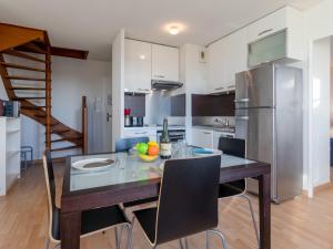 kuchnia ze stołem, krzesłami i lodówką w obiekcie Apartment La Presqu'île-7 by Interhome w mieście Cabourg