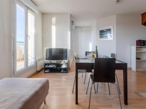 un soggiorno con tavolo e TV di Apartment La Presqu'île-7 by Interhome a Cabourg