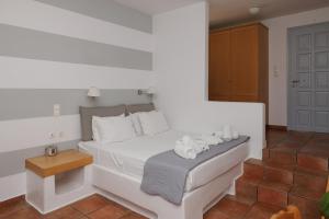 - une chambre avec un lit blanc et des serviettes dans l'établissement Maryo Village, à Náoussa