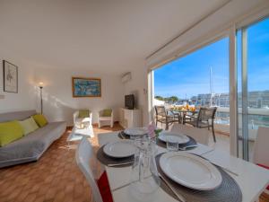 a living room with a table and a couch at Apartment Les Régates by Interhome in Le Grau-du-Roi