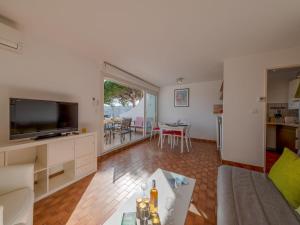 a living room with a flat screen tv and a couch at Apartment Les Régates by Interhome in Le Grau-du-Roi