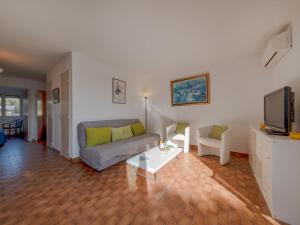 a living room with a couch and a tv at Apartment Les Régates by Interhome in Le Grau-du-Roi +20 photos