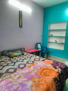 een slaapkamer met een bed met een kleurrijke deken bij jharana guest house in Puri
