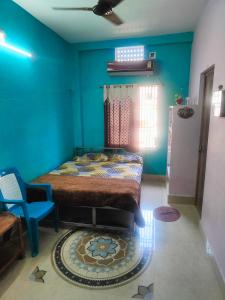 1 dormitorio con cama y pared azul en jharana guest house en Puri