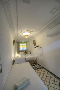 a room with two beds in it with a window w obiekcie Riad dar Yamna w Fezie