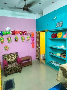 a room with a chair and a colorful wall at jharana guest house in Puri