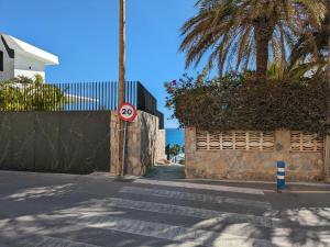 a street with a speed limit sign and palm trees at Apartment Don Miguel III by Interhome in Cala de Finestrat