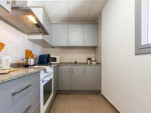 una cocina con armarios blancos y electrodomésticos blancos en Holiday Home Gaviota 6 by Interhome, en Riumar