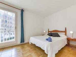 a bedroom with a bed and a large window at Apartment Platja de Roses-8 by Interhome in Roses