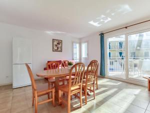 cocina y comedor con mesa de madera y sillas en Apartment Platja de Roses-8 by Interhome, en Roses