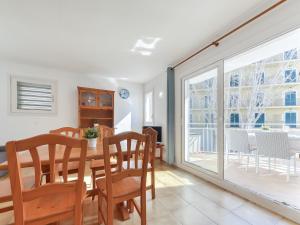 a dining room with a table and chairs and a balcony at Apartment Platja de Roses-10 by Interhome in Roses