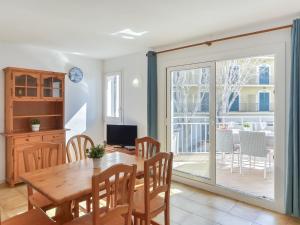 a dining room with a wooden table and a sliding glass door at Apartment Platja de Roses-10 by Interhome in Roses