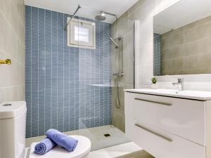 a bathroom with a toilet and a sink and a shower at Apartment Platja de Roses-11 by Interhome in Roses