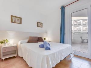 a bedroom with a white bed and a balcony at Apartment Platja de Roses-9 by Interhome in Roses
