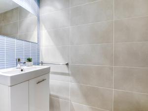 Baño blanco con lavabo y espejo en Apartment Platja de Roses-9 by Interhome, en Roses
