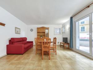 a living room with a red couch and a table at Apartment Platja de Roses-11 by Interhome in Roses