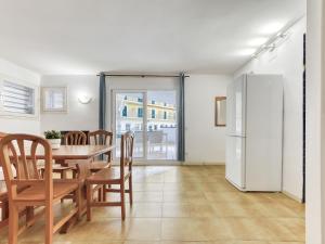 a kitchen and dining room with a table and a refrigerator at Apartment Platja de Roses-11 by Interhome in Roses +15 photos