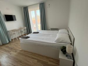 Schlafzimmer mit einem Bett, einem Tisch und einem Fenster in der Unterkunft Milutinn-Trešnja in Sokobanja