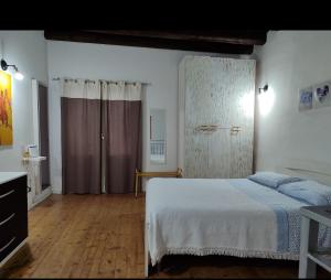 Schlafzimmer mit einem Bett und Holzboden in der Unterkunft A' casuzza in Palermo