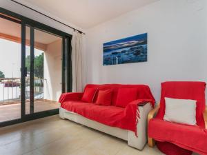 a living room with a red couch and two chairs at Apartment Escorxador by Interhome in L'Escala