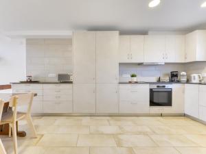 a kitchen with white cabinets and a table at Holiday Home Port Emporda by Interhome in Empuriabrava