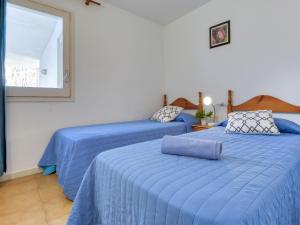 ロザスにあるApartment Platja de Roses-2 by Interhomeのベッドルーム1室(青いシーツと窓付きのベッド2台付)