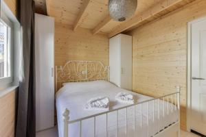 um quarto com uma cama branca numa parede de madeira em Moyo Kijani em Zandvoort