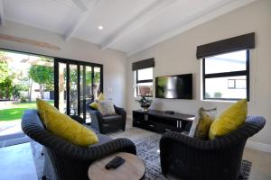 a living room with two chairs and a television at SAFFRON COTTAGE in Hermanus