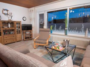 a living room with a couch and a table at Holiday Home Albatross by Interhome in Norddeich