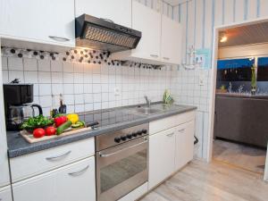 a kitchen with a sink and fruits and vegetables on a counter at Holiday Home Albatross by Interhome in Norddeich