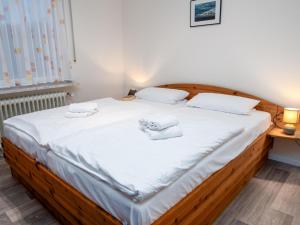 a bedroom with a large bed with white sheets at Holiday Home Albatross by Interhome in Norddeich