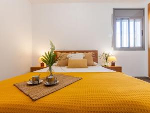 a bedroom with a large bed with a yellow blanket at Holiday Home Gaviota 9 by Interhome in Riumar
